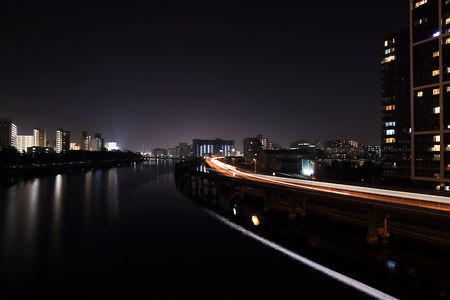 東京モノレールを走る電車の光跡と京浜運河